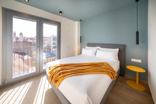a bedroom with a bed and a large window at Sun & Moon Barcelona Airport in El Prat de Llobregat