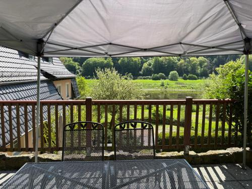 a table and two chairs under a tent on a deck at Ferienwohnung Fluss & Fels in Stadt Wehlen