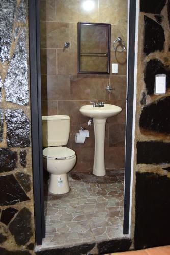 a bathroom with a toilet and a sink at POSAD FAMILIAR EL PARAiSO in Xilitla
