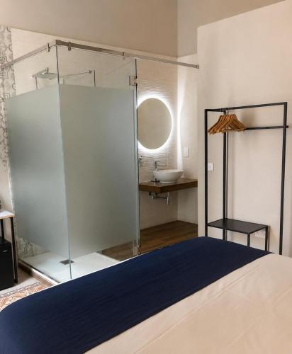 a bedroom with a bed and a bathroom with a sink at Mulberry Suites by The LVH Collection in Valletta