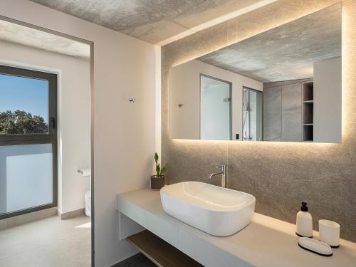 a bathroom with a white sink and a mirror at Hesperian Luxury Villas with Private Heated Pools in Chania
