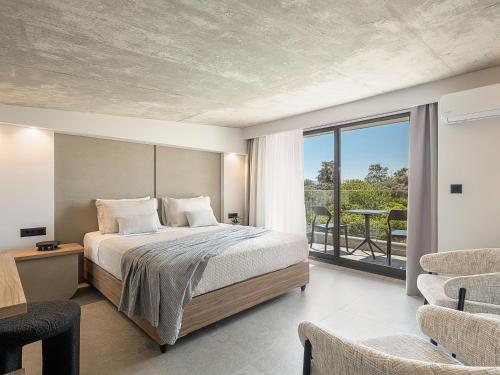 a bedroom with a bed and a balcony at Hesperian Luxury Villas with Private Heated Pools in Chania