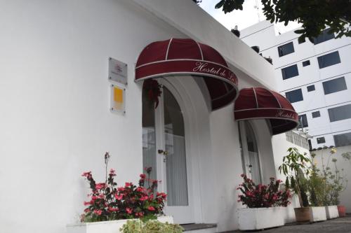 a white building with two balconies and flowers at La Rabida Hotel Boutique in Quito