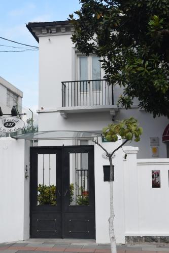 a white building with a black door and a balcony at La Rabida Hotel Boutique in Quito