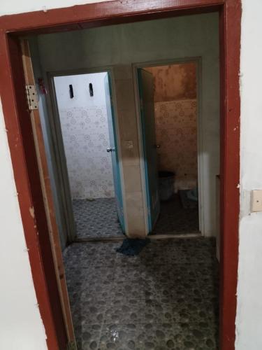 an open door into a bathroom with a hallway at Kahardi guest house in Sengkol