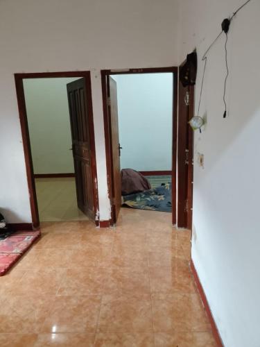 an empty room with two doors and a tile floor at Kahardi guest house in Sengkol