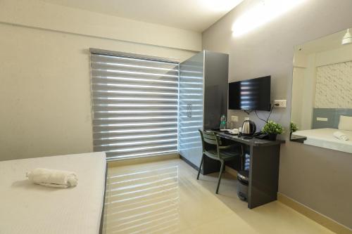 a room with a desk and a computer in a room at D Mirage Hotels in Cochin