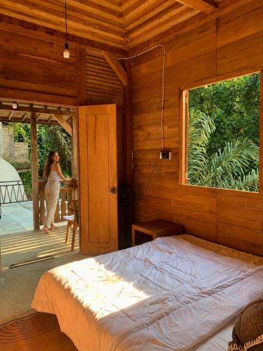 a woman standing outside of a bedroom with a bed at Verdana Jungle Retreat Ubud in Ubud