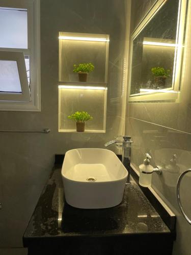 a bathroom with a white sink on a black counter at Leila Home Garden - Maamourah Beach in Alexandria