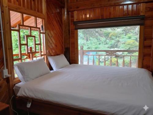 a bed in a wooden room with a window at Sapa Rock Hill Homestay in Tả Van