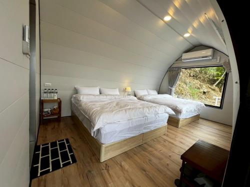 a bedroom with two beds and a window at 歐森View包棟Villa x 雲海夜景 x 獨立空間 in Dongshi