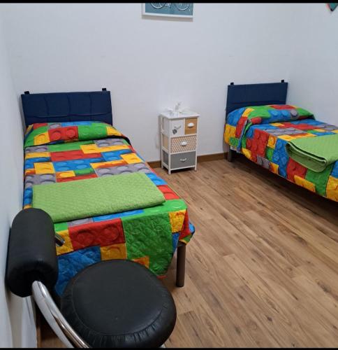a bedroom with two beds and a chair in it at casa S Leonardo in Crotone