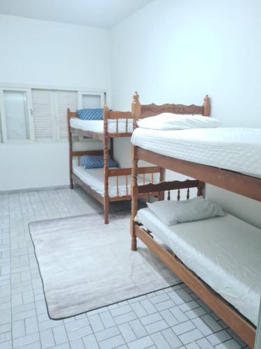 a room with several bunk beds on the floor at Beach Hostel do Japa in Ubatuba