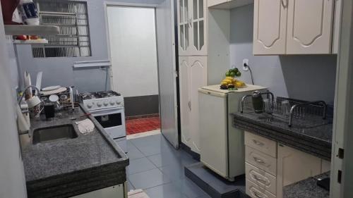 a small kitchen with a sink and a refrigerator at Beach Hostel do Japa in Ubatuba