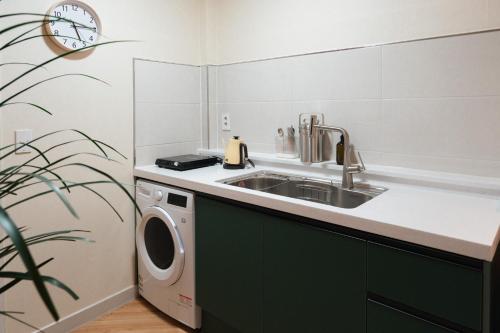 a kitchen with a sink and a washing machine at Stay SUM in Kwarye
