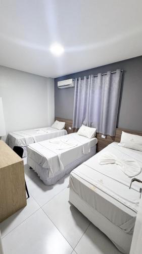 a hospital room with three beds in it at Hotel Novo Sol in Petrolina