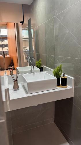 a bathroom with a white sink and a mirror at Hotel Novo Sol in Petrolina