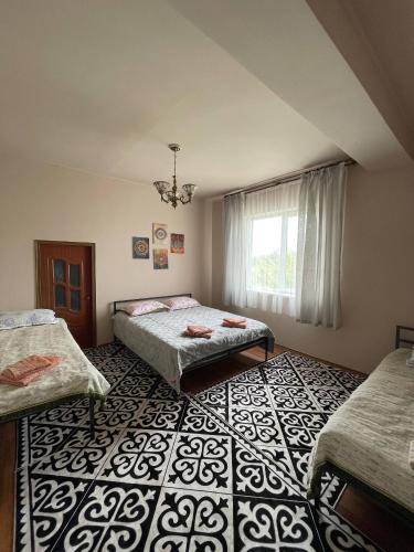 a bedroom with two beds and a window at Wings Ethno in Cholpon-Ata