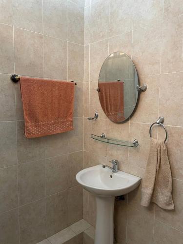 a bathroom with a sink and a mirror and towels at Wings Ethno in Cholpon-Ata
