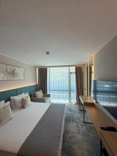 a hotel room with a large bed and a couch at ELIA MARe Hotel ALL Inclusive - Free Beach Access in Kiten