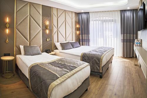 a hotel room with two beds and a window at Elysia Hotel in Istanbul