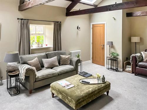 a living room with a couch and a table at Cloggy Nook Tughall in Swinhoe