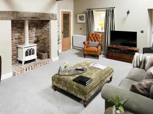 a living room with a couch and a fireplace at Cloggy Nook Tughall in Swinhoe
