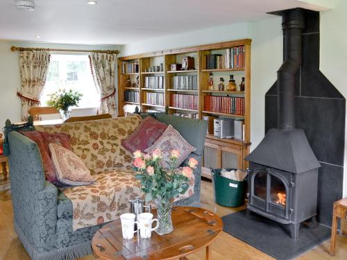 a living room with a couch and a fireplace at The Appleloft in Westleigh