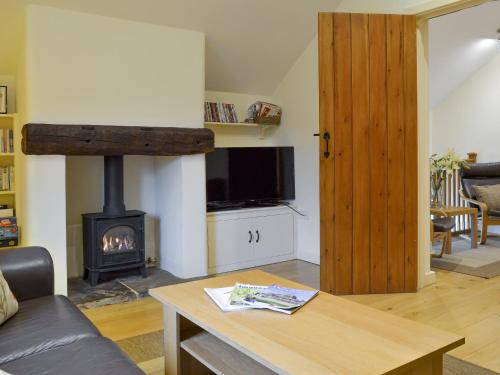 a living room with a fireplace and a stove at Tythe Barn in Froggatt