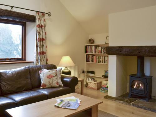 a living room with a couch and a fireplace at Tythe Barn in Froggatt