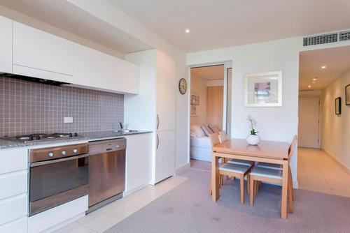 a kitchen with a wooden table and a table and a table at Glenelg Holiday Apartments-Pier in Adelaide