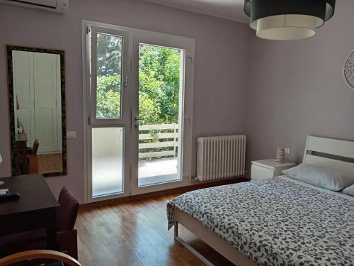 a bedroom with a bed and a desk and a window at Home Meditamondo in Fano