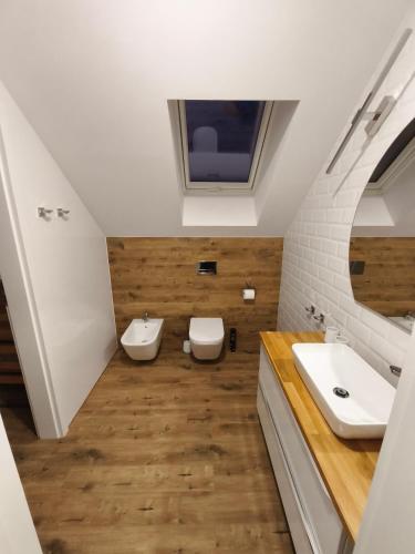 a bathroom with two sinks and two toilets at Kropla Rosy 27 in Orchówek
