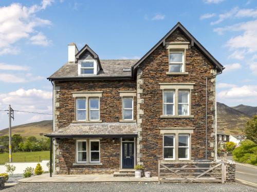 a brick house with white windows on a street at Mount Pleasant in Threlkeld