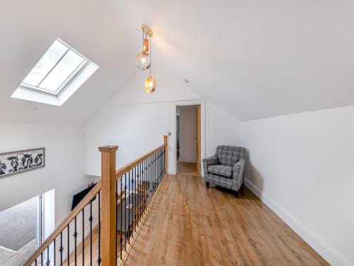 a room with a staircase with a chair and a skylight at Ty Godro - Uk12745 in Acrefair