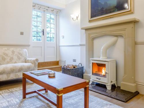 a living room with a fireplace and a coffee table at Eagles Nest At Greyfriars - Uk33356 in Winchelsea