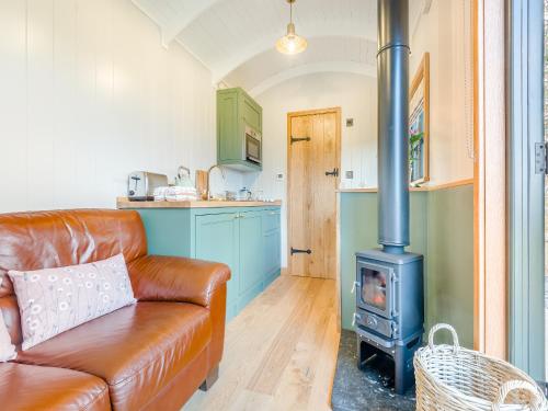 a living room with a couch and a stove at Hut Uk42176 in Usk
