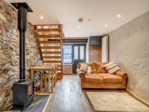 a living room with a couch and a wood stove at Stable Cottage in Pembroke