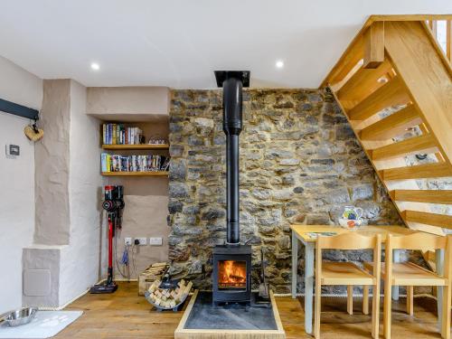 a fireplace in a living room with a stone wall at Stable Cottage in Pembroke