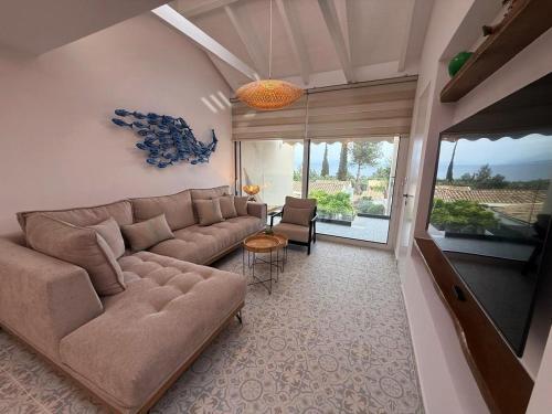 a living room with a large couch and a table at Villa Metaxa Barbati Beach Corfu in Barbati