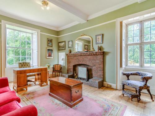 a living room with a fireplace and a red couch at Hodroyd Hall in Holmfirth
