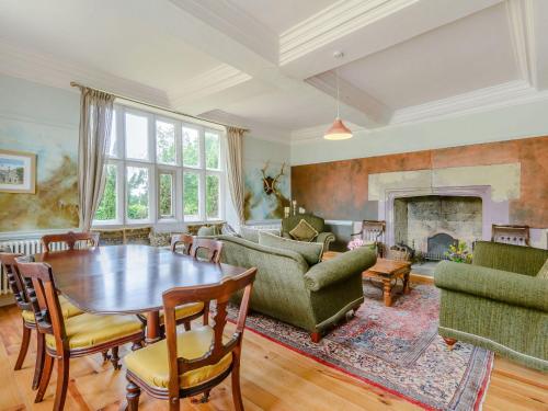 a living room with a table and a fireplace at Hodroyd Hall in Holmfirth