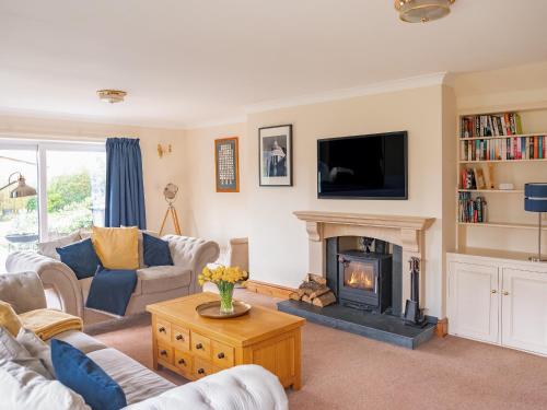 a living room with a fireplace and a tv at Cranny Hill in Walpole