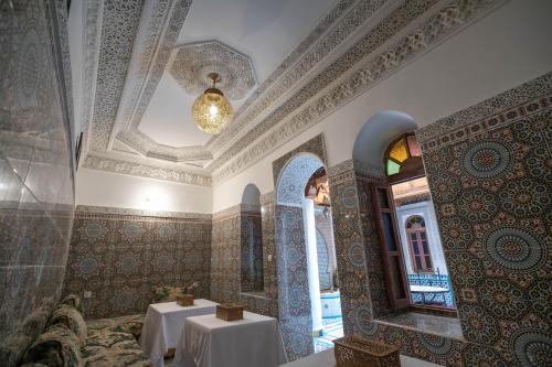 a dining room with two tables and a ceiling at Riad Medina Unique in Fez
