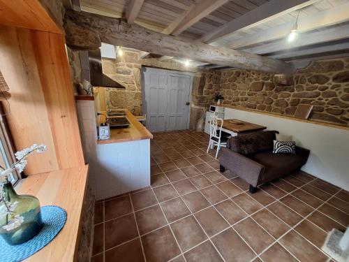 a kitchen and living room with a couch and a table at Casa de mestre 2 in Freijo