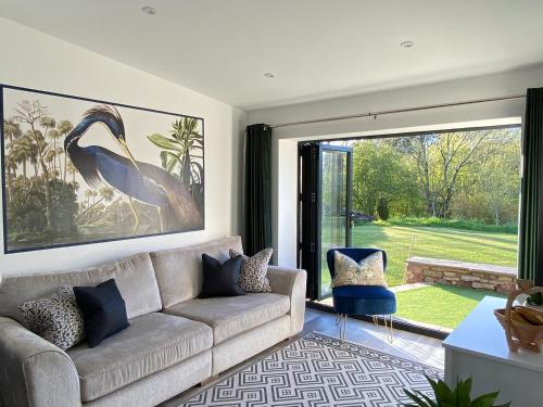 a living room with a couch and a large window at Blue Heron Lodge in Brough