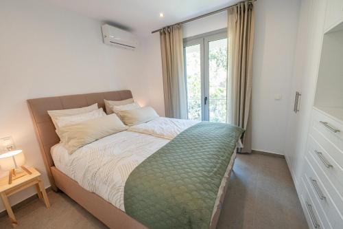 a bedroom with a bed with a large window at Villa Yvonni in Poros