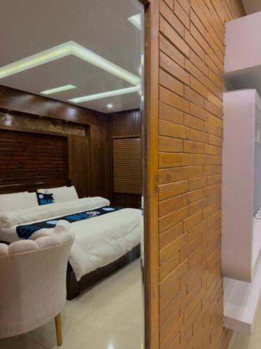 a bedroom with two beds and a brick wall at Go Glam Hotels Murree in Murree