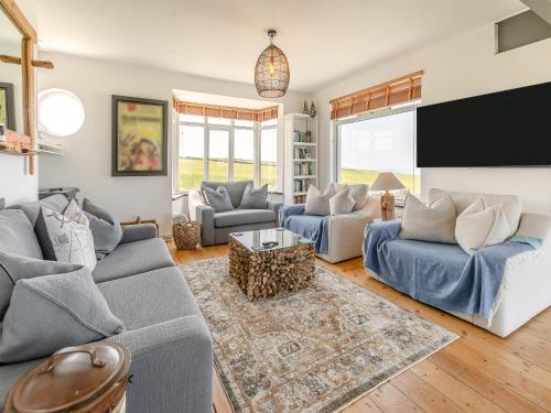 a living room with two couches and a tv at Lower Hendra Cottage in Port Isaac
