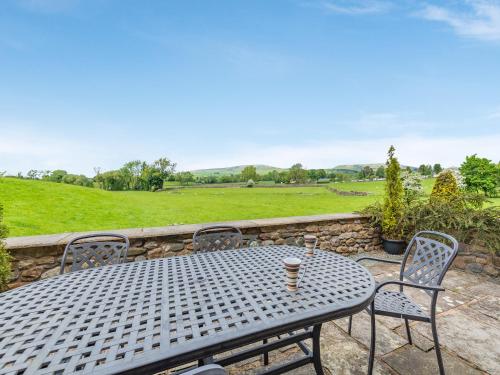 a metal table and chairs with a cup of coffee on it at Warth Barn - Uk44211 in Ingleton